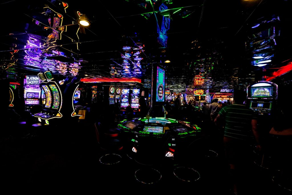 L'intérieur d'un casino plongé dans le noir avec les lueurs colorées des machines à sous