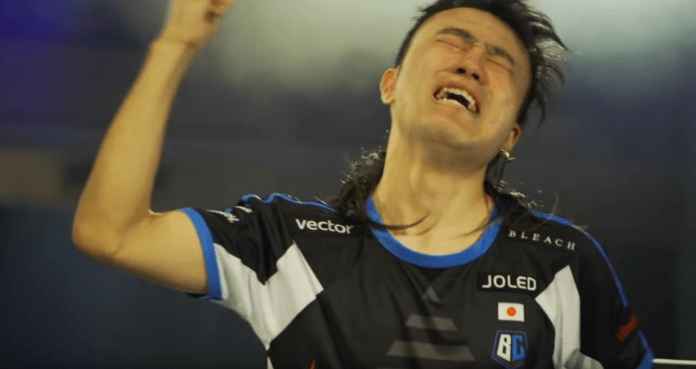 Le joueur de Dragon Ball FighterZ Tachikawa pleurant de joie et levant la bras droit pour montrer sa victoire