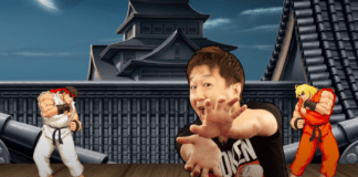 Yoshinori Ono de chez Capcom qui mime un hadoken avec les mains jointes devant une partie de street Fighter II