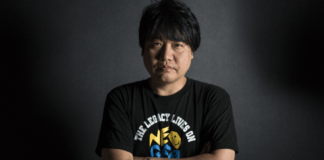 Le producteur de SNK Yasuyuki Oda croisant les bras et portant un t-shirt noir Neo Geo