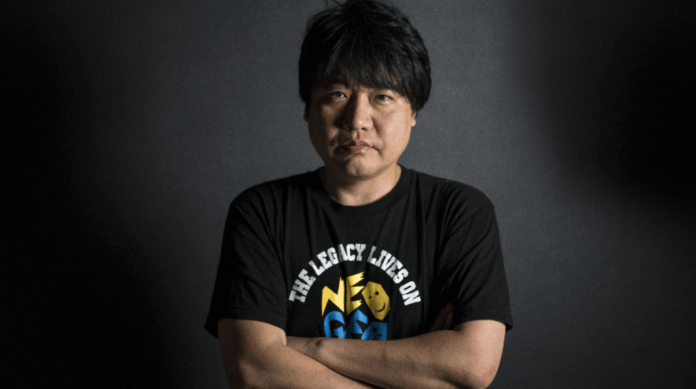 Le producteur de SNK Yasuyuki Oda croisant les bras et portant un t-shirt noir Neo Geo