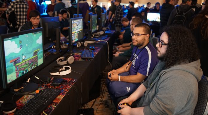 Deux joueurs assis manette en main devant un écran lors d'un tournoi de jeux de combat