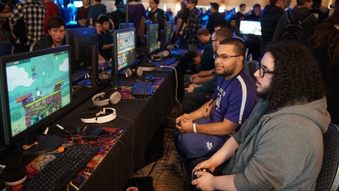 Deux joueurs assis manette en main devant un écran lors d'un tournoi de jeux de combat