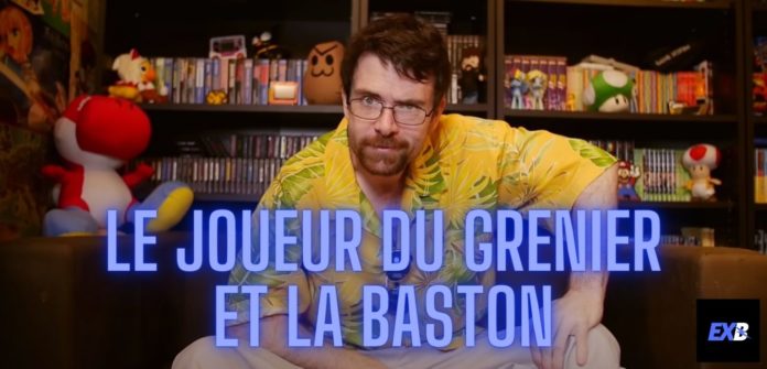 Le Joueur du Grenier alias JDG avec sa chemise jaune et assis sur son canapé