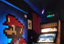 Borne d'arcade Street Fighter avec mario peint sur le mur d'à côté