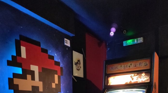 Borne d'arcade Street Fighter avec mario peint sur le mur d'à côté