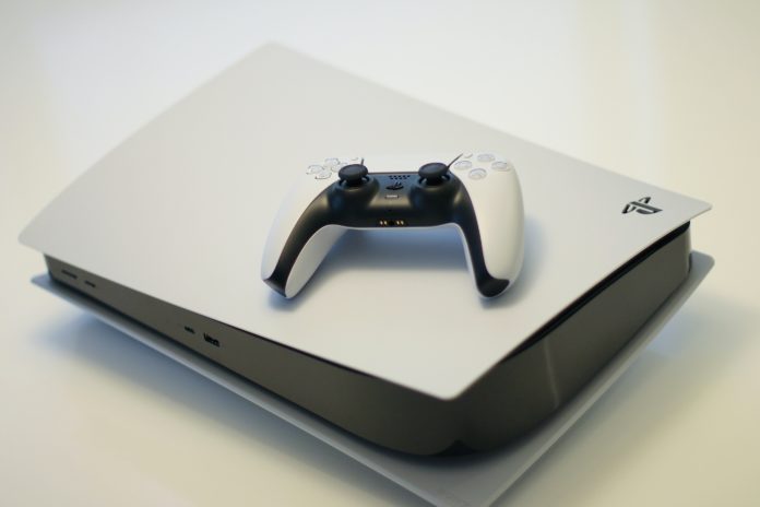 Console Playstation 5 blanche avec une manette posée dessus