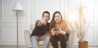 Un couple qui joue aux jeux vidéo assis sur une chaise