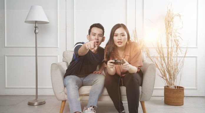 Un couple qui joue aux jeux vidéo assis sur une chaise